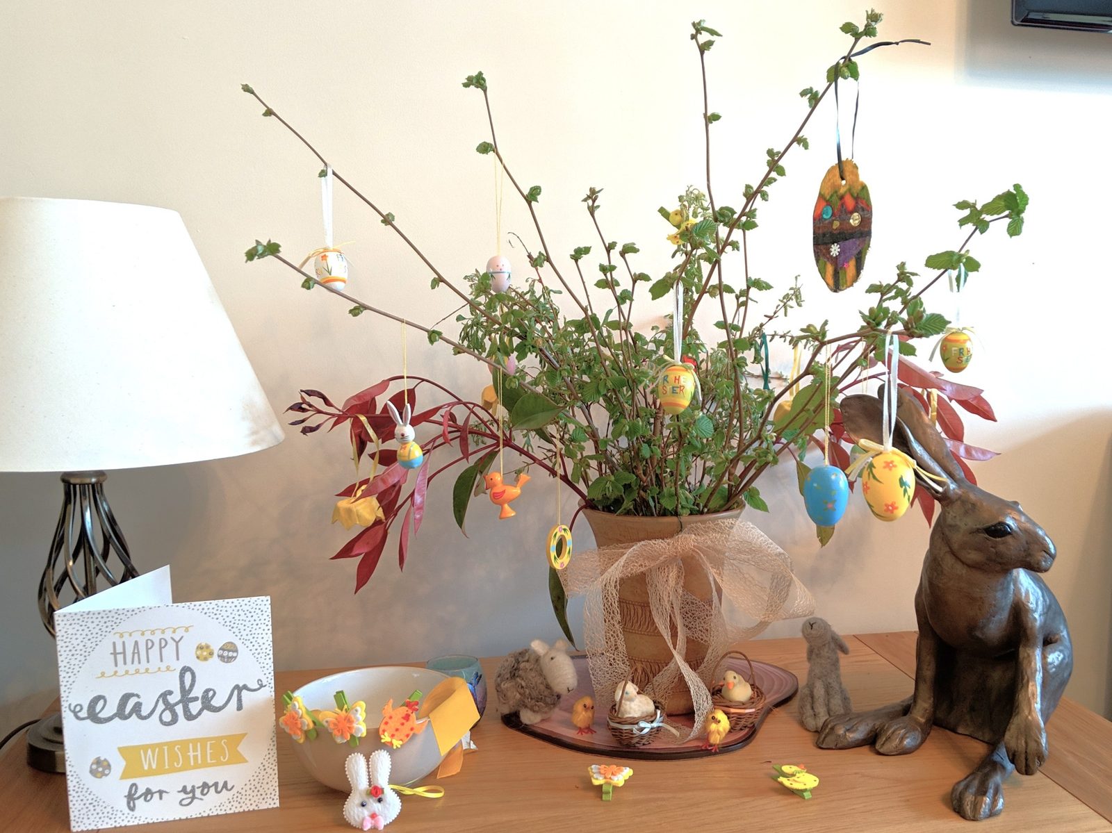 An Easter tree with painted eggs and a bronze hare