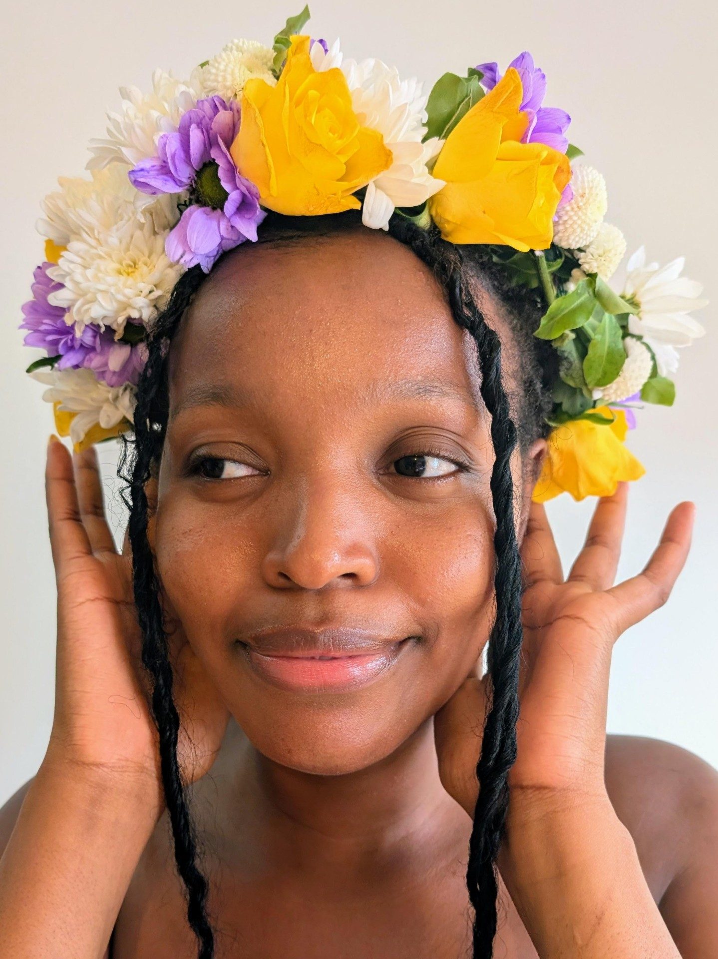 A woman wearing a flower crown of roses, daisies and asters