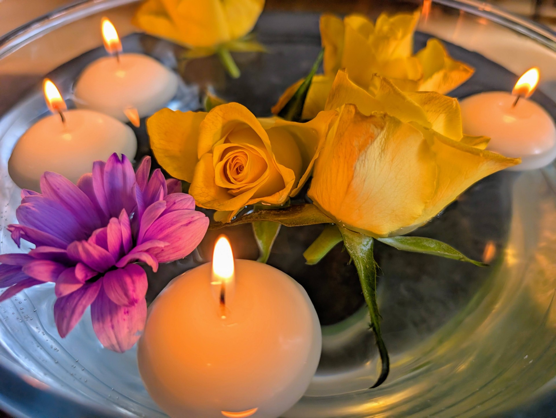 Floating candles and roses in a bowl of water